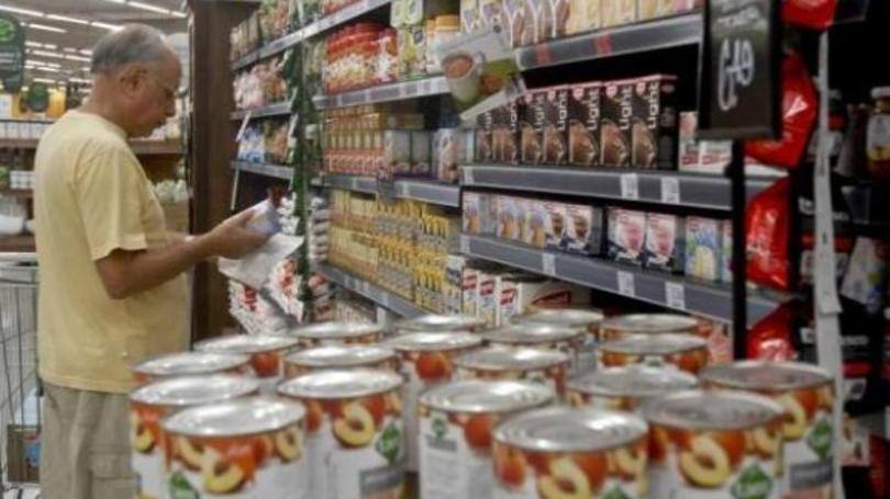 Consumidor faz compras em supermercado. Comércio