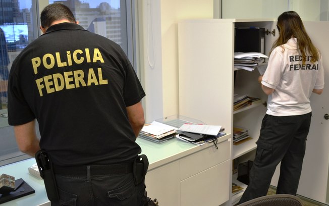 Agentes da Polícia Federal investigam documentos apreendidos durante a Operação Lava Jato