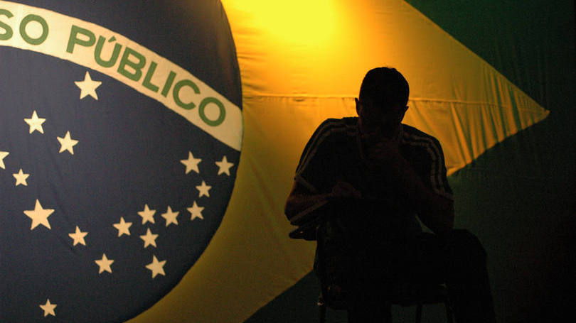 homem-sentado-bandeira-concurso-publico