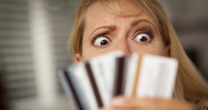 A perplexed woman looking at various credit cards